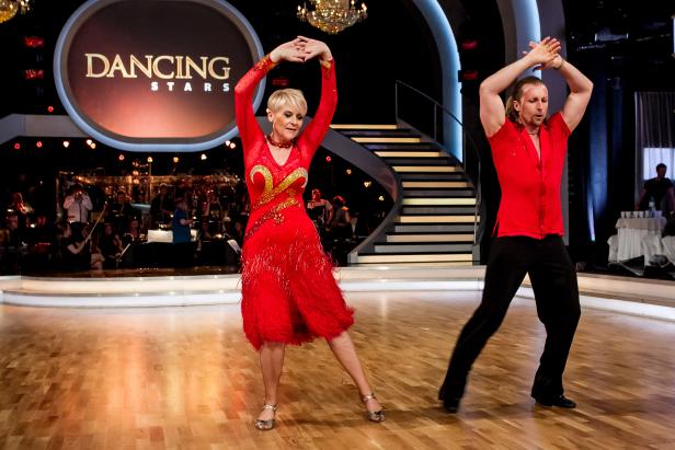 Ein Tanzpaar in roten Kostümen tanzt auf der Bühne von „Dancing Stars“.