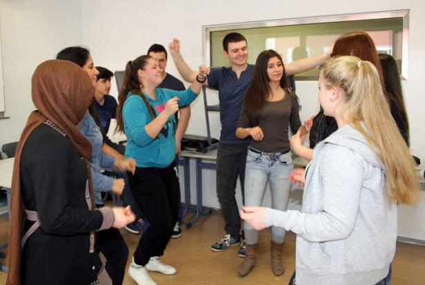 Eine Gruppe junger Leute tanzt und hat Spaß in einem Raum.