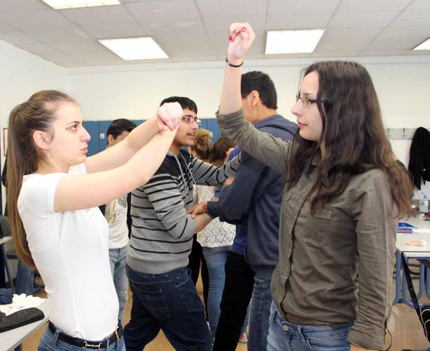Eine Gruppe junger Leute interagiert miteinander in einem hellen Raum.