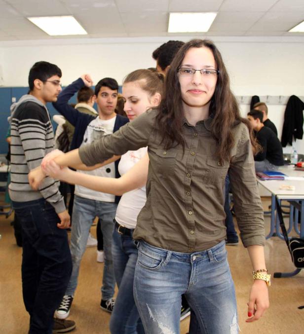 Eine Gruppe von Jugendlichen steht in einem Klassenzimmer.