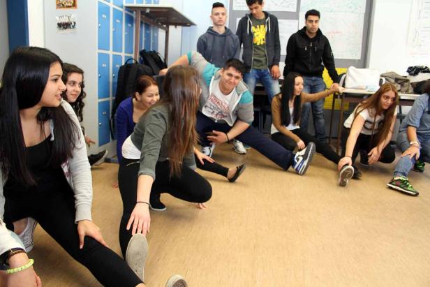 Eine Gruppe von Schülern dehnt sich in einem Klassenzimmer.