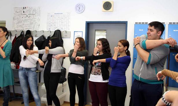 Eine Gruppe von Schülern dehnt sich in einem Klassenzimmer.