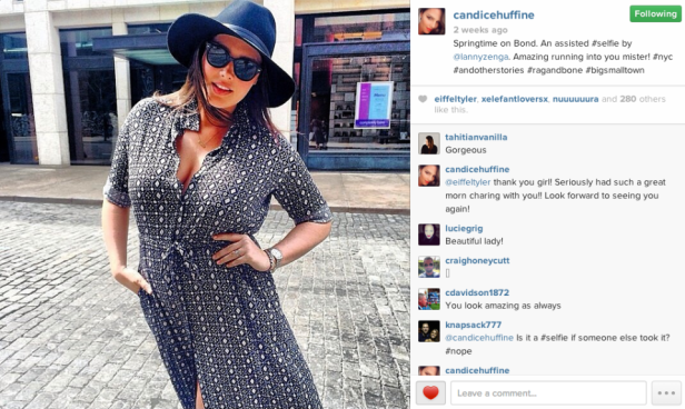 Eine Frau mit Hut und Sonnenbrille posiert auf einer Straße.