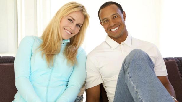 Lindsey Vonn und Tiger Woods sitzen lächelnd auf einem Sofa.