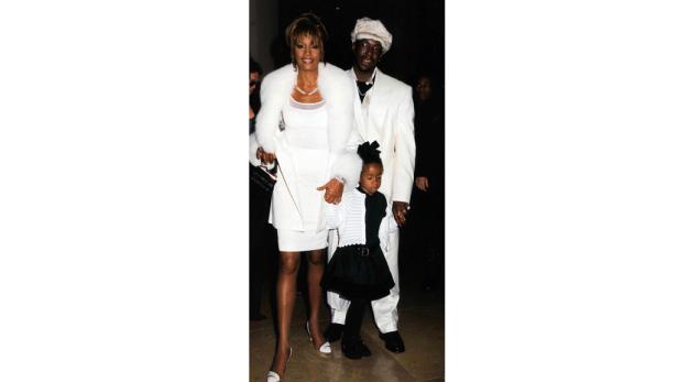 Whitney Houston, Bobby Brown und ihre Tochter posieren für ein Foto.