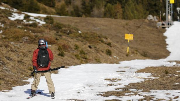 Ein Skifahrer wird einen Hang hinaufgezogen.