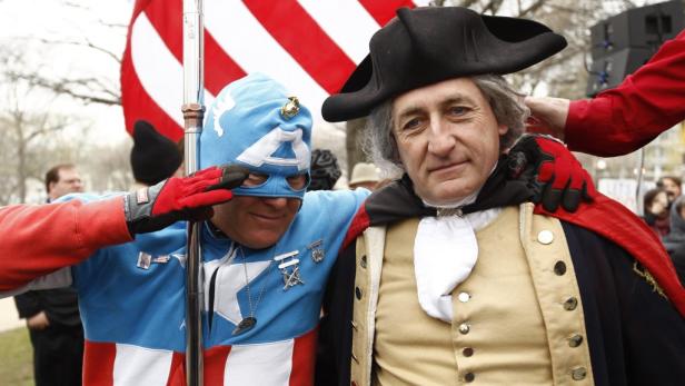 Eine Person im Captain America-Kostüm salutiert neben George Washington-Doppelgänger.