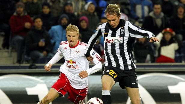 Zwei Fußballspieler kämpfen um den Ball während eines Spiels.