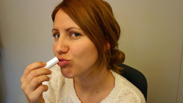 Eine Frau trägt Lippenbalsam auf.