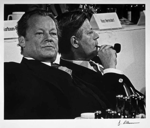 Willy Brandt und Helmut Schmidt sitzen zusammen, Schmidt raucht Pfeife.