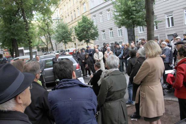 Eine Menschenmenge versammelt sich auf einer Straße, während ein Klarinettist spielt.