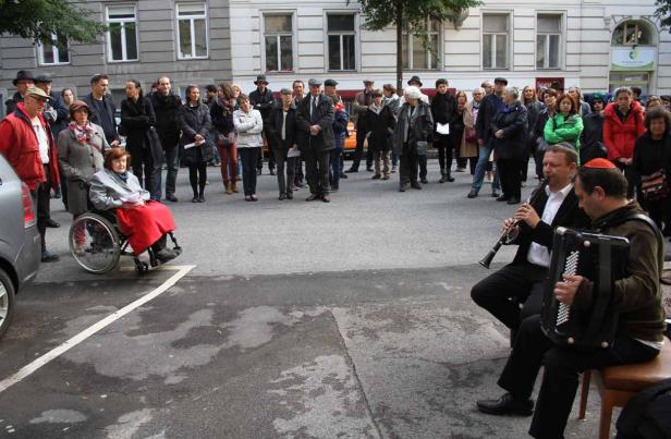 Zwei Musiker spielen Klarinette und Akkordeon vor einer Menschenmenge auf der Straße.