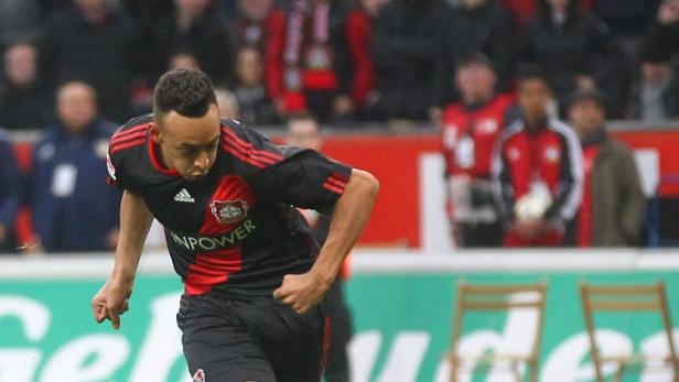Ein Fußballspieler in einem schwarz-roten Trikot läuft auf dem Spielfeld.