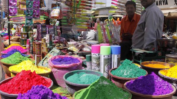 Ein Marktstand mit farbigem Pulver und Sprays für das Holi-Fest.