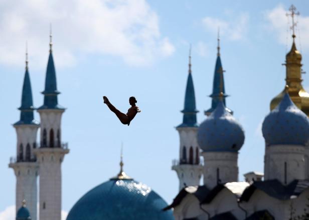 Ein Turmspringer in der Luft vor der Kulisse der Kul-Scharif-Moschee in Kasan.
