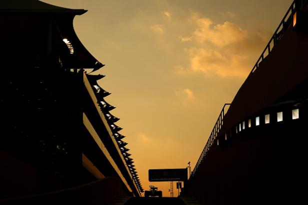 Ein Formel-1-Wagen fährt auf einer Rennstrecke unter einem orangefarbenen Himmel.