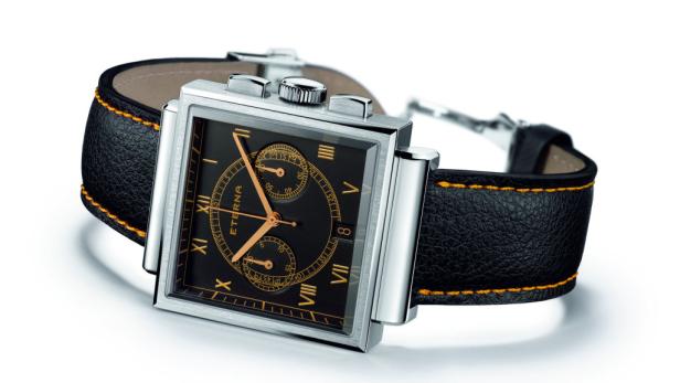 Eine quadratische Eterna-Armbanduhr mit schwarzem Zifferblatt und Lederarmband liegt auf einem weißen Hintergrund.