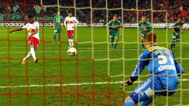 Ein Fußballspieler schießt einen Elfmeter auf das Tor.