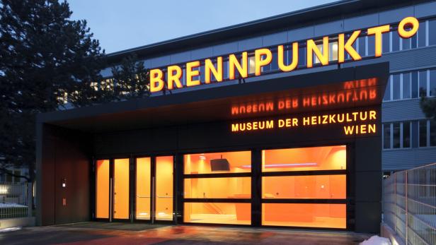 Das Museum der Heizkultur in Wien bei Nacht mit leuchtender Beschriftung „Brennpunkt“.