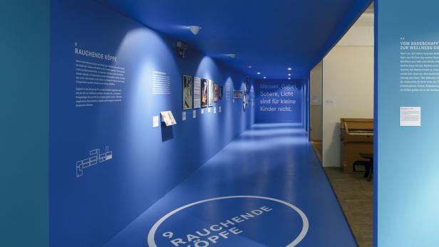 Ein Ausstellungsraum in Blau mit dem Slogan „Messer, Gabel, Schere, Licht sind für kleine Kinder nicht.“.