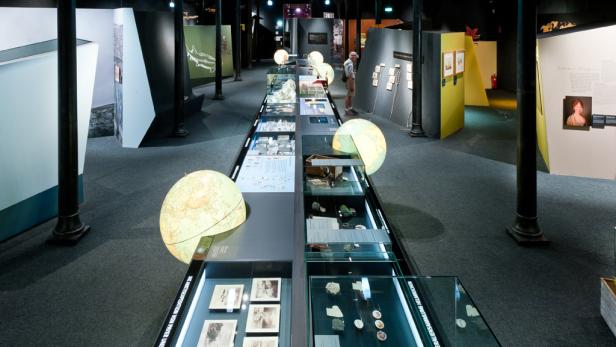 Blick in einen Ausstellungsraum mit Vitrinen und Globen.