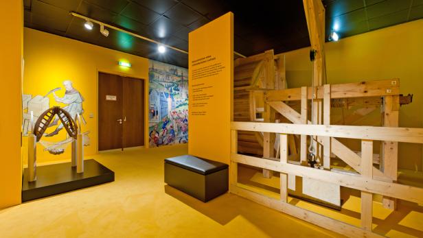 Innenansicht eines Museums mit einer Rekonstruktion eines mittelalterlichen Laufrads.