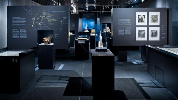 Innenansicht eines Museums mit verschiedenen Ausstellungsstücken in Vitrinen.
