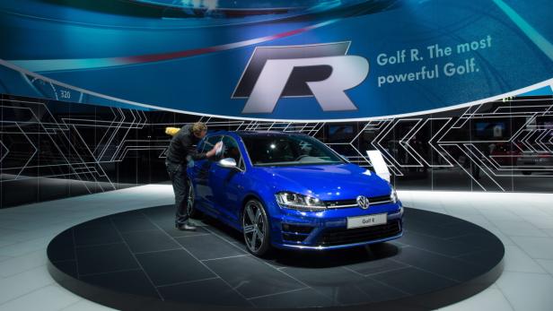 Ein blauer VW Golf R wird auf einer Automesse gereinigt.
