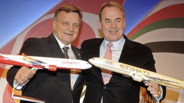 Zwei Männer halten Modelle von Air Berlin- und Etihad-Flugzeugen.
