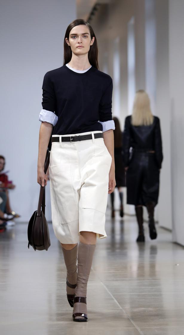 Eine Frau präsentiert Mode auf einem Laufsteg.