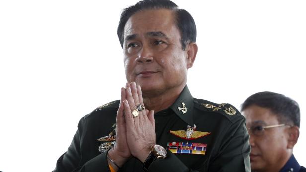 Prayut Chan-o-cha in Militäruniform mit gefalteten Händen.