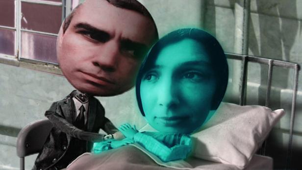 Ein Mann im Anzug besucht eine Frau, die in einem Krankenhausbett liegt.