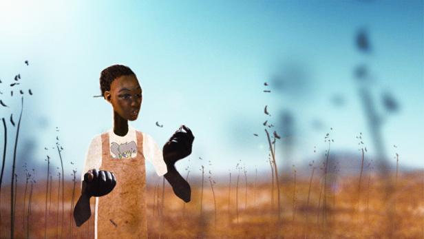 Ein junger Mann steht in einem Feld mit hohem Gras.