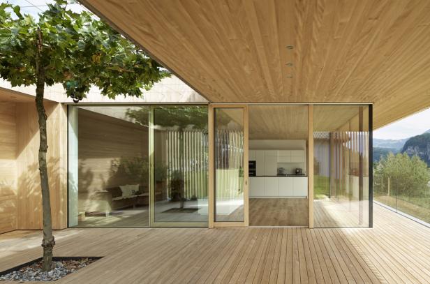 Ein modernes Holzhaus mit großen Glasfronten und einer Terrasse.