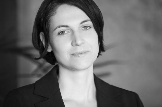 Schwarzweiß-Porträt einer Frau mit dunklen, kurzen Haaren und einem Blazer.