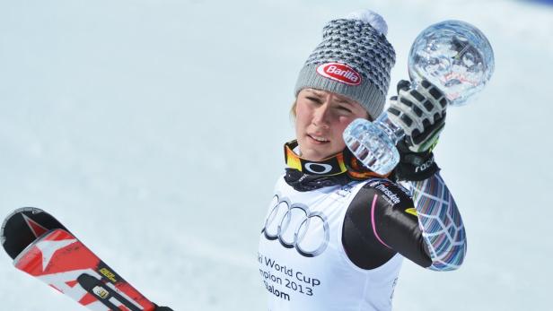 Eine Skirennläuferin hält einen Kristallpokal in die Höhe.