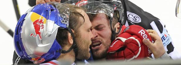 Zwei Eishockeyspieler geraten aneinander, einer trägt einen Helm mit Red Bull-Logo.