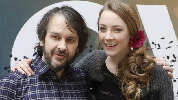 Peter Jackson und Saoirse Ronan posieren zusammen vor einer Filmkulisse.