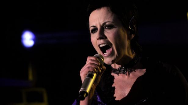 Dolores O'Riordan, die Sängerin von The Cranberries, singt in ein Mikrofon.