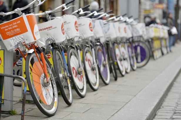 Eine Reihe von Fahrrädern des Anbieters ING-DiBa stehen auf einem Bürgersteig.