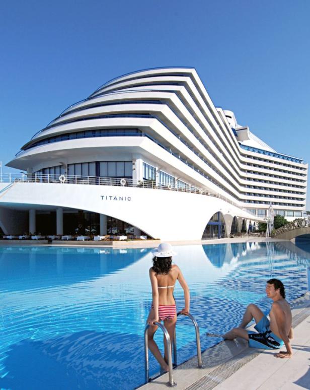Ein Paar entspannt am Pool des Titanic Hotels, das wie ein Kreuzfahrtschiff gestaltet ist.
