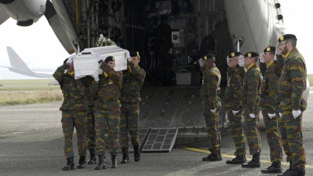 Soldaten tragen einen Sarg aus einem Flugzeug.