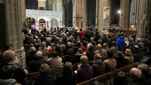 Eine Menschenmenge sitzt in einer Kirche während eines Gottesdienstes.