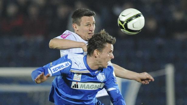 Zwei Fußballspieler kämpfen um einen Ball in der Luft.