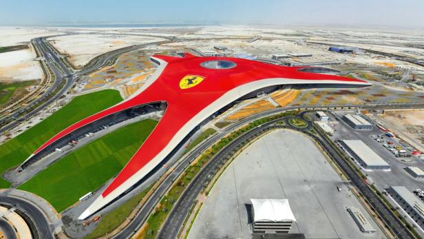 Luftaufnahme der Ferrari World in Abu Dhabi mit ihrem markanten roten Dach.