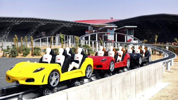 Eine Achterbahn im Ferrari World Abu Dhabi, deren Wagen wie Ferraris aussehen.