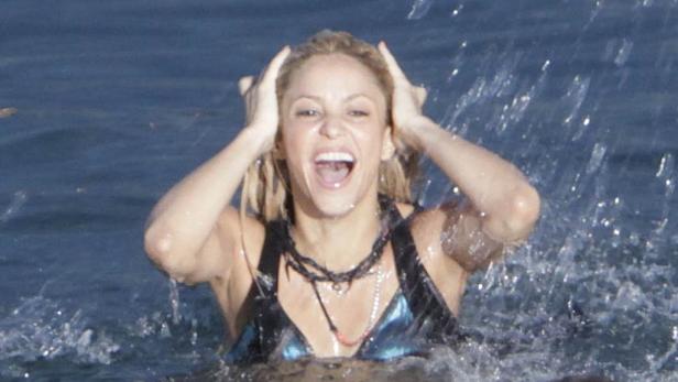 Shakira steigt lachend aus dem Wasser.