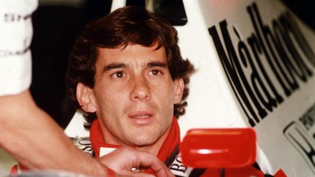 Ayrton Senna sitzt im Cockpit seines Rennwagens.