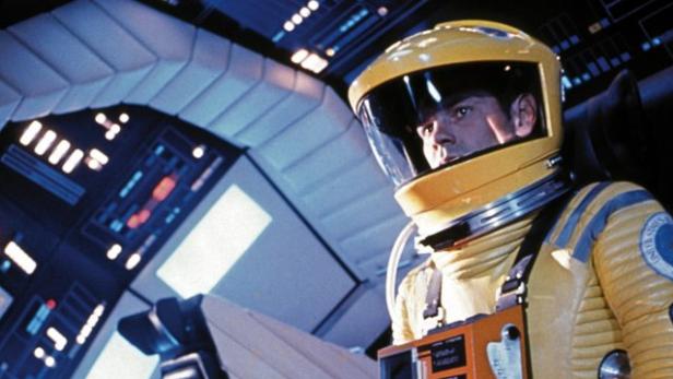 Ein Astronaut in einem gelben Raumanzug in einem Raumschiff.