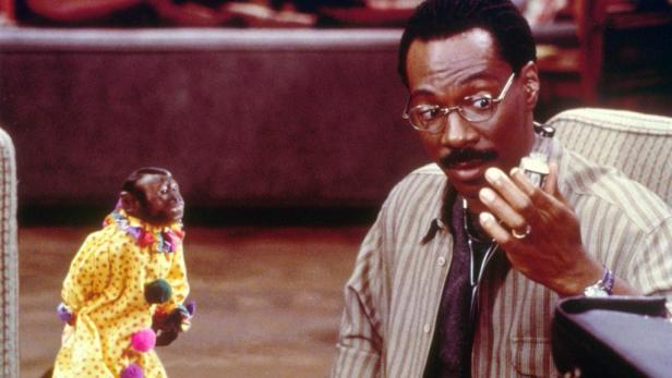 Eddie Murphy als Dr. Dolittle untersucht einen Affen, der als Clown verkleidet ist.